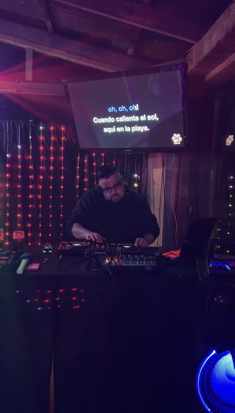 DJ en la cabina con la letra del karaoke en pantalla