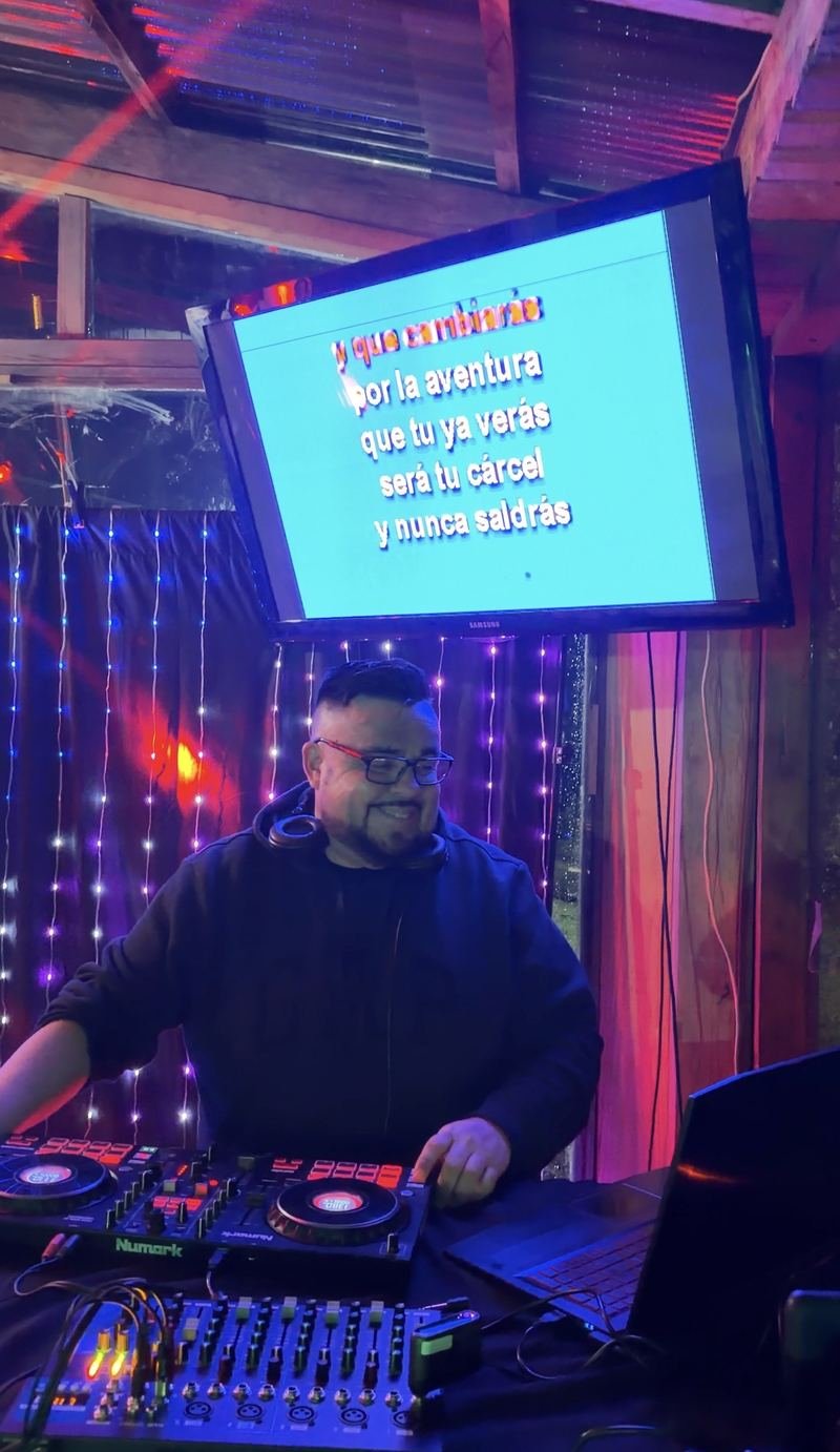 DJ en un local con pantalla de karaoke y cortina LED