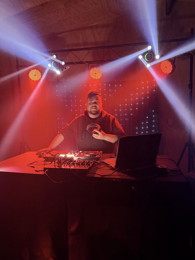 DJ en la cabina con luces robóticas rojas