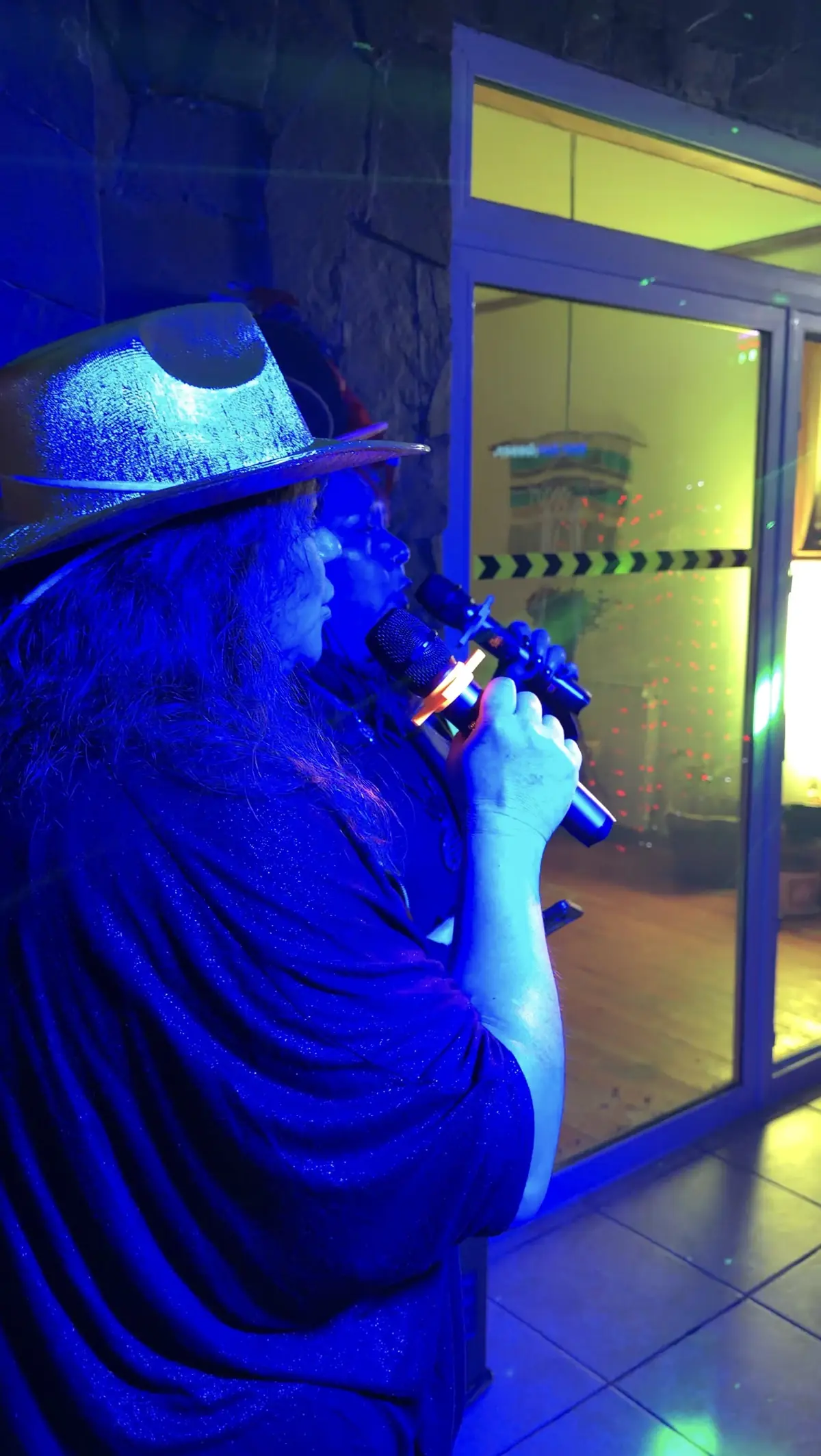 Invitada cantando karaoke bajo luz azul