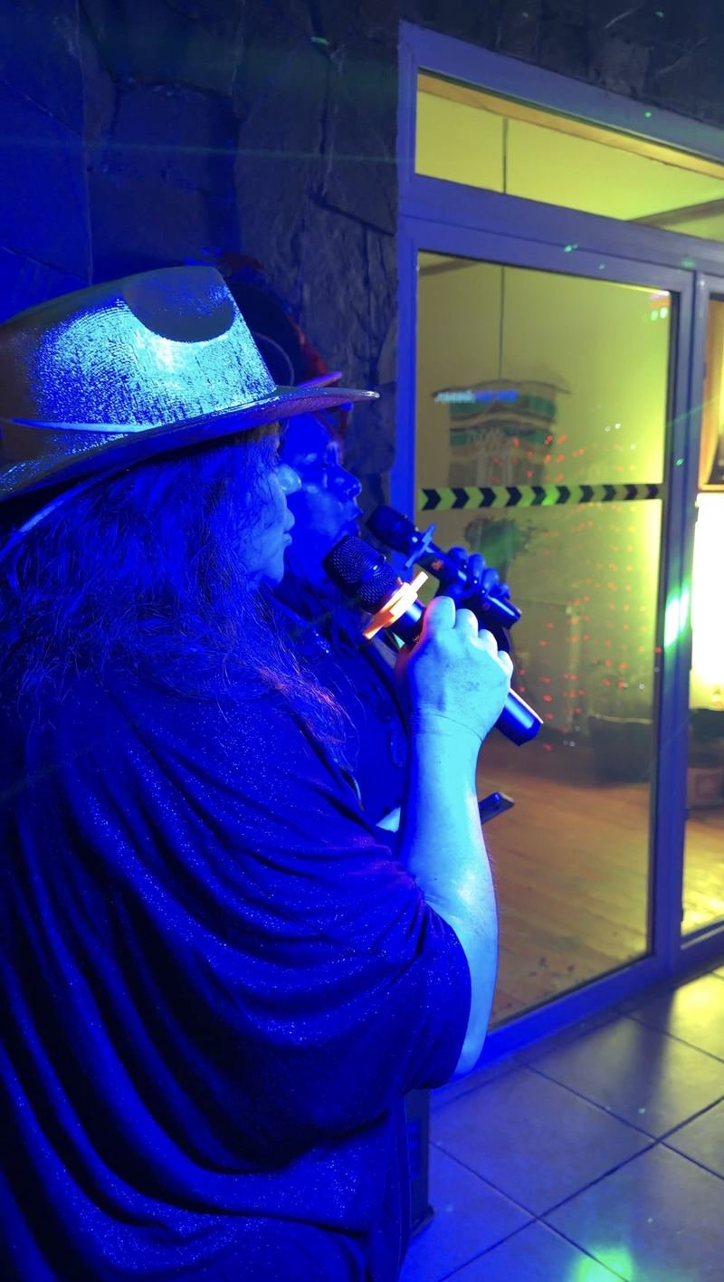 Invitada cantando karaoke bajo luz azul