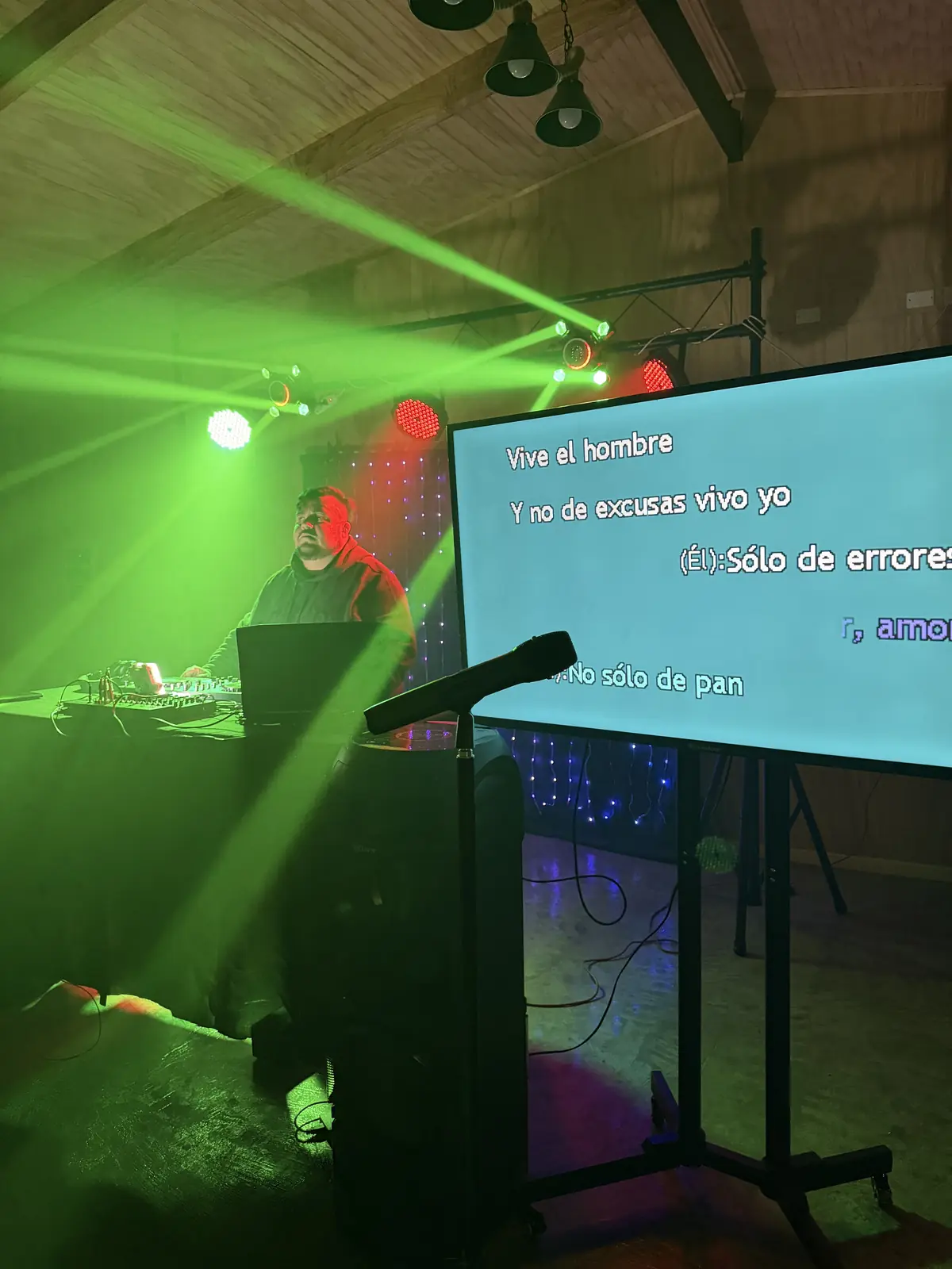 Micrófono frente a la pantalla de karaoke con luces verdes