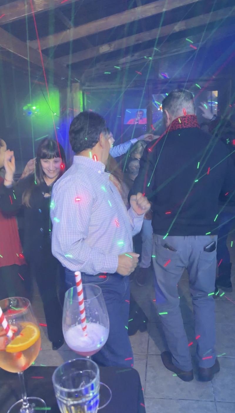 Invitados bailando con luces de colores en una celebración