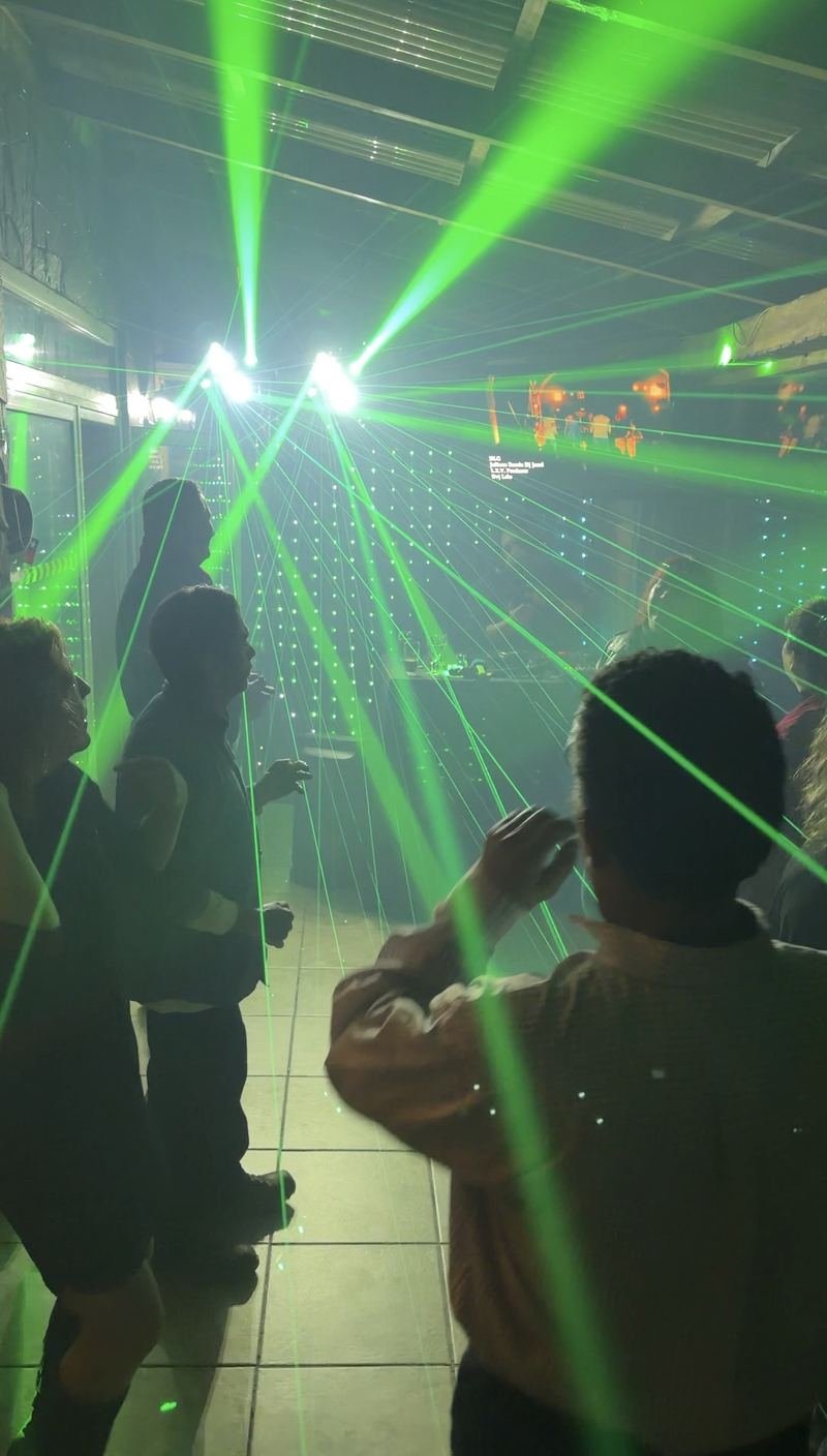Invitados bailando bajo luces láser verdes