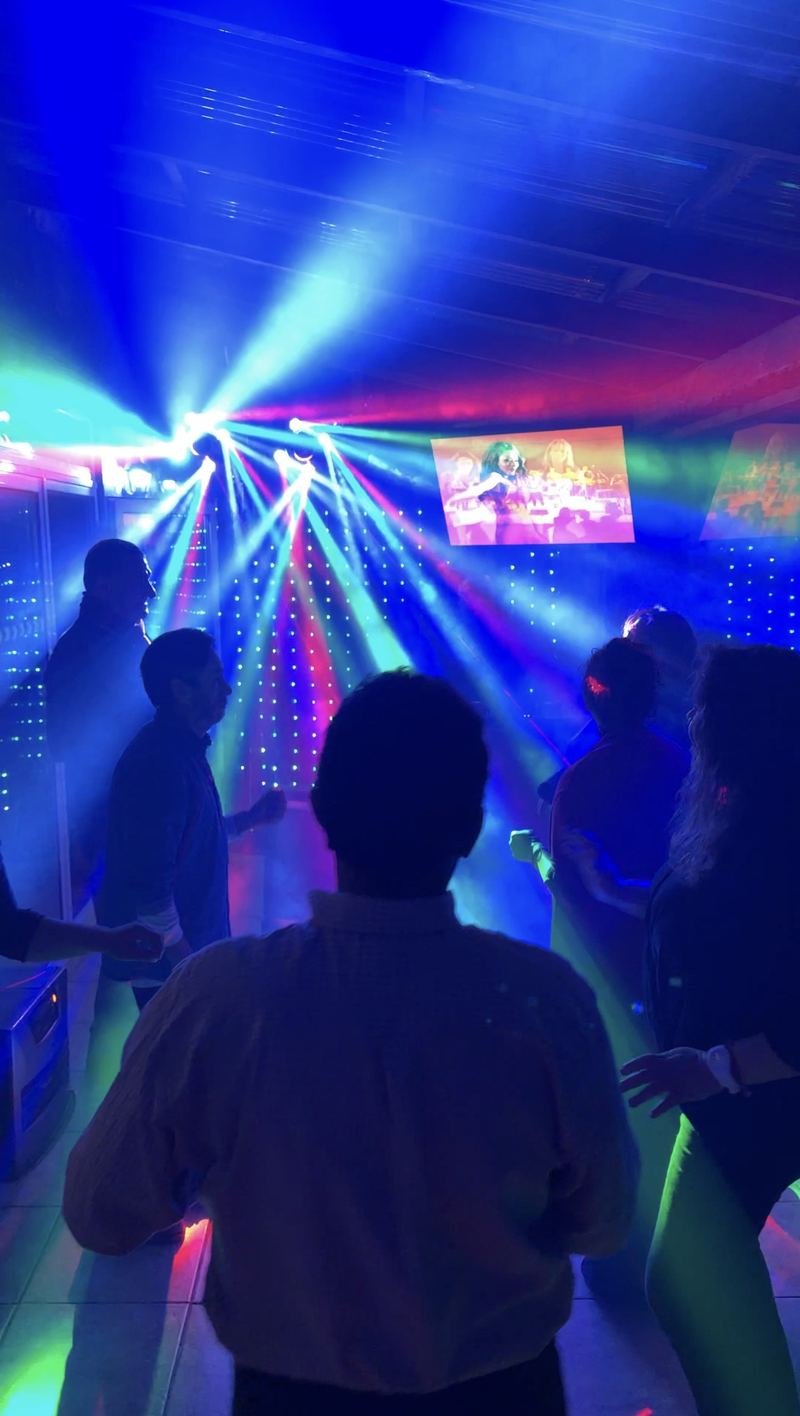 Pista de baile llena bajo luces robóticas azules